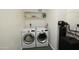 Efficient laundry room featuring a washer, dryer, storage shelves, and a water treatment system at 3015 E Sells Dr, Phoenix, AZ 85016