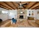 Cozy living room with beamed ceiling, stone fireplace, and tile floors at 3015 E Sells Dr, Phoenix, AZ 85016