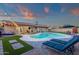 Relaxing backyard with a sparkling pool, artificial grass, and comfortable lounge chairs under a vibrant sunset sky at 3121 E Sierra St, Phoenix, AZ 85028