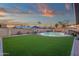 Expansive backyard features green turf, a refreshing pool, patio furniture, and block wall for privacy at 3121 E Sierra St, Phoenix, AZ 85028