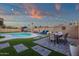 Beautiful backyard features a pool, lounge area, outdoor dining set, lush artificial grass, and festive string lights at 3121 E Sierra St, Phoenix, AZ 85028