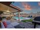 Spacious covered patio overlooking the pool, complete with comfortable seating, a grill, and stylish pavers at 3121 E Sierra St, Phoenix, AZ 85028