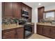 Well-lit kitchen featuring granite countertops, tile backsplash, and dark wood cabinetry at 3121 E Sierra St, Phoenix, AZ 85028