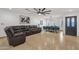 Open-concept living space with tile floors, a large sectional sofa, and an adjacent dining area at 3121 E Sierra St, Phoenix, AZ 85028