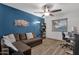 Cozy living room with wood-look floors, textured blue walls, and a ceiling fan at 3121 E Sierra St, Phoenix, AZ 85028