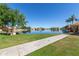 Tranquil lake view features a sidewalk, community gazebo, lush grass, and waterfront houses at 3140 N 114Th Dr, Avondale, AZ 85392