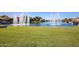 Scenic lake view showcases lush green grass leading to waters with fountains and waterfront homes at 3140 N 114Th Dr, Avondale, AZ 85392