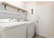 Well-lit laundry room with white washer, dryer, and shelving for storage at 3140 N 114Th Dr, Avondale, AZ 85392