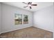Bright bedroom with two large windows, a ceiling fan and neutral carpet at 3592 E Sandwick Dr, San Tan Valley, AZ 85140