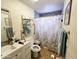 Well-lit bathroom features a modern vanity, stylish tile accents, and a shower with Paris themed curtain at 3621 N 65Th Ave, Phoenix, AZ 85033