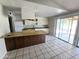 Open kitchen with white cabinets, island and sliding glass door to patio at 3621 N 65Th Ave, Phoenix, AZ 85033