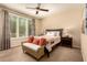 Well-lit bedroom featuring a large window, ceiling fan, and comfortable bed with decorative pillows at 3910 N 163Rd Dr, Goodyear, AZ 85395