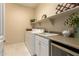 Functional laundry room equipped with washer, dryer, sink, and storage cabinets at 3910 N 163Rd Dr, Goodyear, AZ 85395