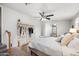 Well-lit bedroom showcasing a ceiling fan, comfortable bed, and clothing rack at 3925 E Arbor Ave, Mesa, AZ 85206