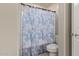Bright bathroom with a blue patterned shower curtain, white toilet, and neutral wall color at 3929 S 79Th Ln, Phoenix, AZ 85043