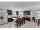 Modern kitchen featuring dark cabinetry, granite countertops, stainless steel appliances, and a central island with seating at 3929 S 79Th Ln, Phoenix, AZ 85043
