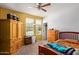 Cozy bedroom featuring bright, neutral walls, a ceiling fan, and warm-toned wood furniture at 5218 W Lydia Ln, Laveen, AZ 85339