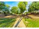 Well-manicured community park featuring a walking path lined with mature trees and greenery at 5218 W Lydia Ln, Laveen, AZ 85339