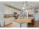 Open kitchen featuring a large island with bar seating, granite countertops, stainless steel appliances, and white cabinets at 5218 W Lydia Ln, Laveen, AZ 85339