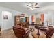 Inviting living room featuring comfortable leather seating, neutral walls, a ceiling fan, and wood-look floors at 5218 W Lydia Ln, Laveen, AZ 85339