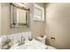 Cozy bathroom with a decorative mirror, wallpaper, and white-tiled sink at 537 N Jay St, Chandler, AZ 85225