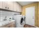Well-lit laundry room featuring a washer, dryer, and tile countertops at 537 N Jay St, Chandler, AZ 85225