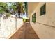 View of the side yard with a white textured wall, decorative tiles, and green trim at 537 N Jay St, Chandler, AZ 85225