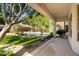 Covered back patio overlooking the pool and lush, landscaped backyard at 6243 E Camelback Rd, Scottsdale, AZ 85251