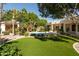 Inviting backyard featuring a sparkling pool, lush landscaping, and well-manicured artificial turf at 6243 E Camelback Rd, Scottsdale, AZ 85251