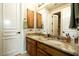 Bathroom with granite countertops, double sinks, and wood cabinets at 6243 E Camelback Rd, Scottsdale, AZ 85251