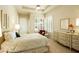 Cozy bedroom with neutral decor, a ceiling fan and a window with plantation shutters at 6243 E Camelback Rd, Scottsdale, AZ 85251