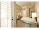 Bright bedroom featuring neutral tones, plush carpet, ceiling fan, and a large window with shutters at 6243 E Camelback Rd, Scottsdale, AZ 85251
