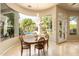 Cozy breakfast nook with a chandelier and views of the lush backyard and pool at 6243 E Camelback Rd, Scottsdale, AZ 85251
