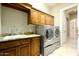 Bright laundry room with modern washer and dryer, sink, and ample cabinet space at 6243 E Camelback Rd, Scottsdale, AZ 85251