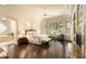 Spacious main bedroom with hardwood floors, ceiling fan, seating area and attached ensuite bathroom at 6243 E Camelback Rd, Scottsdale, AZ 85251
