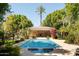 Swimming pool with jacuzzi and pool house surrounded by trees and plants at 6243 E Camelback Rd, Scottsdale, AZ 85251