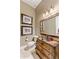 A vintage-style half bathroom featuring unique wood vanity, framed artwork, and elegant lighting fixtures at 700 N Dobson Rd # 54, Chandler, AZ 85224