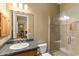 Bright bathroom with walk-in shower, a dark vanity, and a large mirror reflecting the bedroom at 700 N Dobson Rd # 54, Chandler, AZ 85224