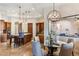 Open-concept dining room with glass table, statement chandelier, and kitchen island with granite countertops at 700 N Dobson Rd # 54, Chandler, AZ 85224