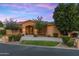 Stunning single-story home boasts meticulous landscaping and a welcoming arched entryway beneath a colorful twilight sky at 700 N Dobson Rd # 54, Chandler, AZ 85224