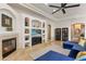 This living room features a fireplace, custom shelving, a ceiling fan, and comfortable couches at 700 N Dobson Rd # 54, Chandler, AZ 85224