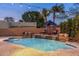 This backyard offers a relaxing pool with small waterfalls, lounge chairs, and subtle uplighting at 700 N Dobson Rd # 54, Chandler, AZ 85224