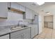 Bright kitchen with stainless sink, gray cabinets, white subway tile backsplash and white appliances at 7765 W Glenn Dr, Glendale, AZ 85303