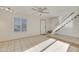 Bright living room with a ceiling fan, tiled floors, and staircase leading to the upper level at 7765 W Glenn Dr, Glendale, AZ 85303