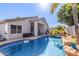 Expansive backyard featuring a sparkling pool, patio area, lush greenery, and mature trees at 7908 W Rose Garden Ln, Peoria, AZ 85382