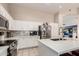 Bright kitchen features white cabinets, stainless steel appliances, and a large island with quartz countertops at 7908 W Rose Garden Ln, Peoria, AZ 85382
