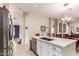 Bright kitchen features white cabinets, stainless steel appliances, and a large island with quartz countertops at 7908 W Rose Garden Ln, Peoria, AZ 85382