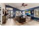 Bright living room with tile flooring, sofa, ceiling fan and large windows at 7908 W Rose Garden Ln, Peoria, AZ 85382