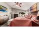 This main bedroom features a ceiling fan, natural light, and beach themed decor at 7908 W Rose Garden Ln, Peoria, AZ 85382