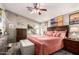 This main bedroom features a ceiling fan, natural light, and beach themed decor at 7908 W Rose Garden Ln, Peoria, AZ 85382